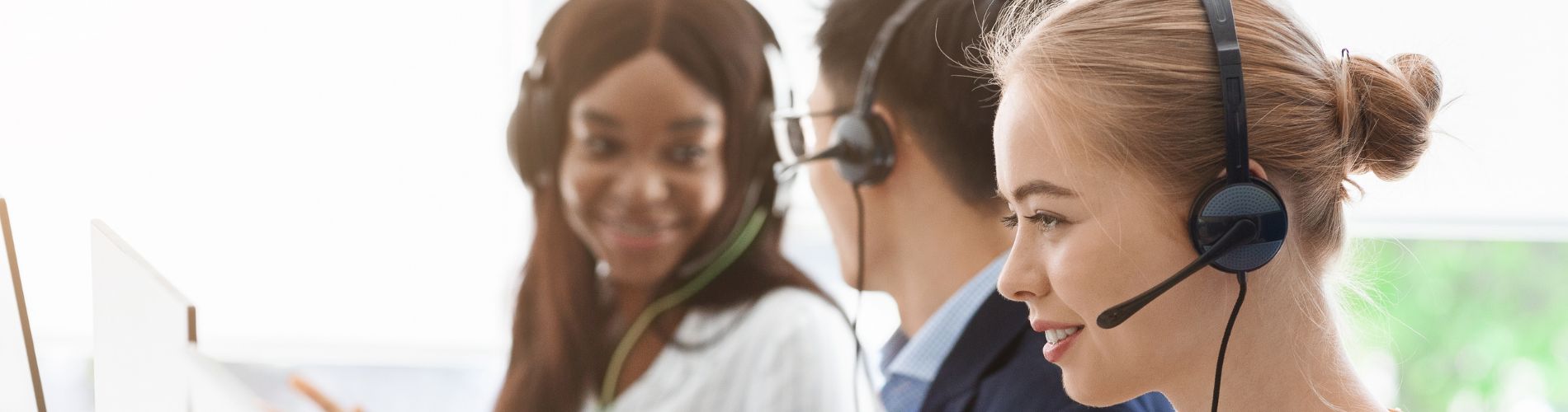 three call centre operators using headsets to manage calls